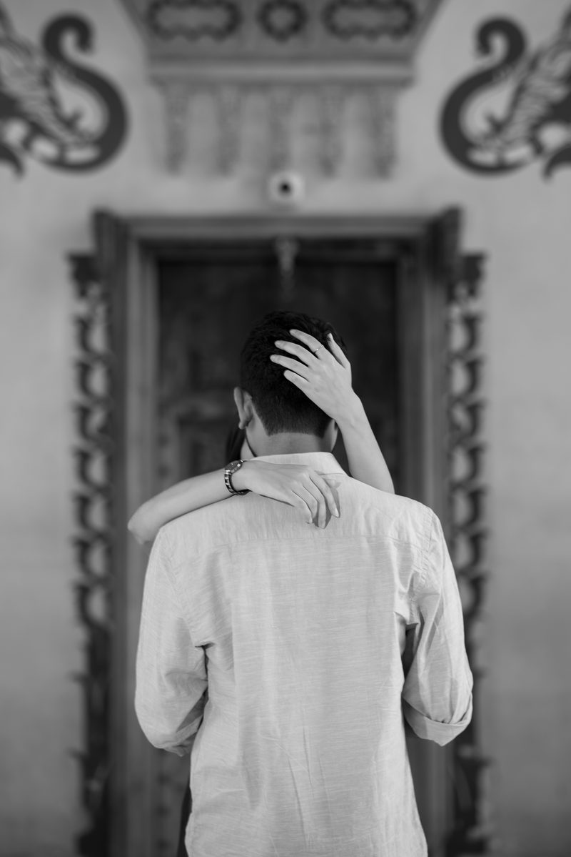Sudhanshu and Ishita in a quiet embrace before a carved haveli doorway